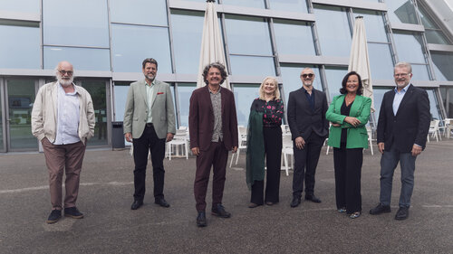 Lehrende Gruppenfoto stehend vor Glasfassade