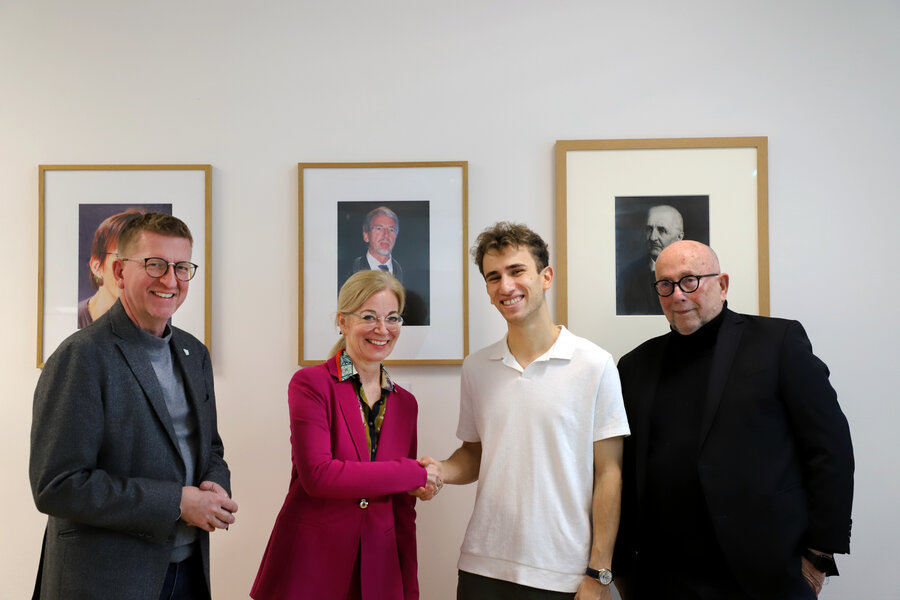 Drei Personen gratulieren Preistraeger