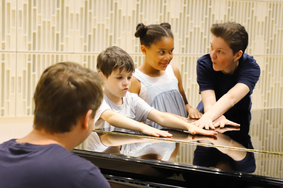 Schuelerinnen und Paedagoginnen am Klavier