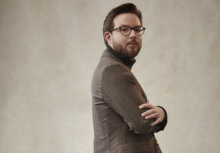 Mann mit Brille und verschraenkten Armen