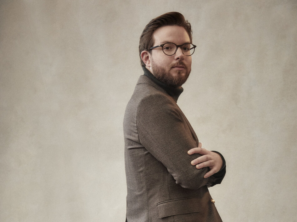 Mann mit Brille und verschraenkten Armen