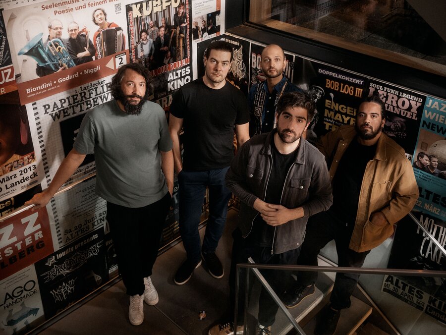 5 musiker vor plakatwand
